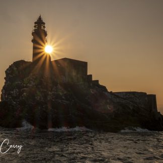 The sun slips behind the Fastnet Rock Lighthouse